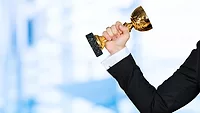 business person's arm holding cup trophy business person's arm holding cup trophy