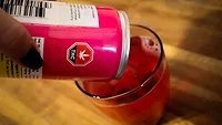 person pouring pink thc beverage into a glass person pouring pink thc beverage into a glass
