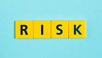 yellow letter tiles on blue background that spell 'risk'
