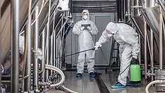 men in hazmat suits cleaning plant