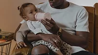 father feeding a baby from a bottle.png father feeding a baby from a bottle