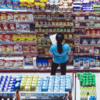 woman checking grocery store shelves