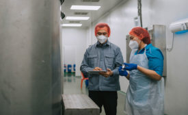 two people working together looking at a tablet in dairy production plant
