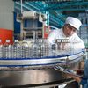people in uniform working at bottling plant