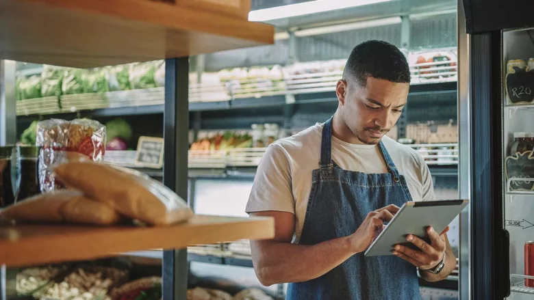 grocery retail worker holding tablet in store