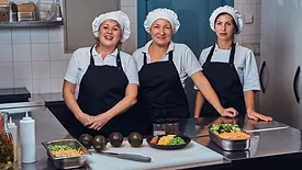 three smiling women kitchen staff