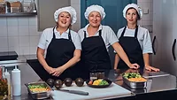 three smiling women kitchen staff
