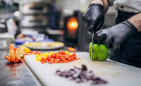 a worker's hands chopping veggies