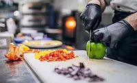 a worker's hands chopping veggies a worker's hands chopping veggies